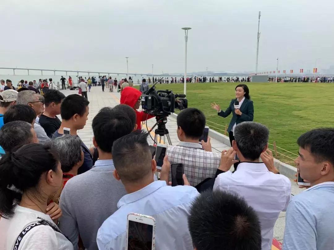 △ 热切关注大桥开通的市民与正在做现场报道的央视记者。（央视记者张淳拍摄）